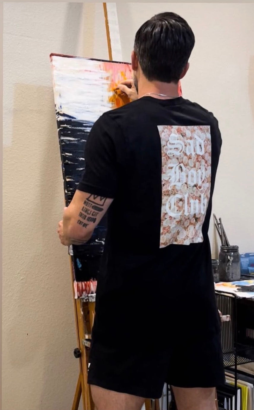 A man wearing a Sadboy back print tee in the studio